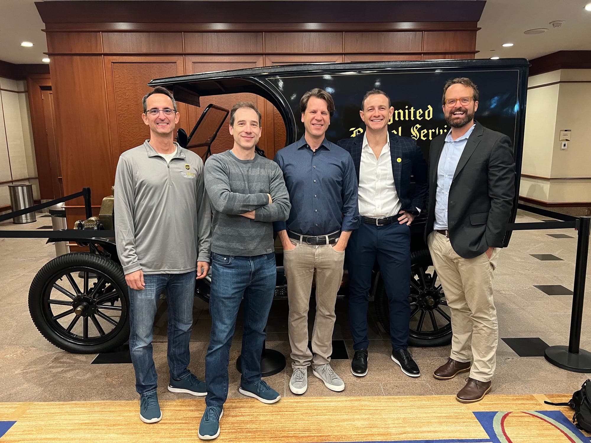 Five members of the executive team standing in front of a vintage United Parcel Service delivery truck.